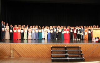 Die Abituienten und Abiturientinnen stehen auf der Bühne der Stadthalle
