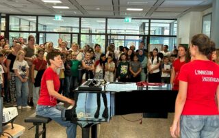 Künftige Fünftklässler und ihre Eltern lauschen dem Schulchor in der Aula des Gymnasiums.