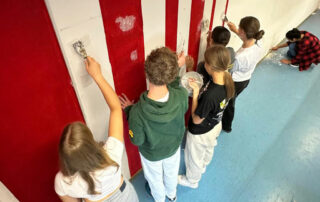 Schülerinnen und Schüler streichen den SMV-Raum.