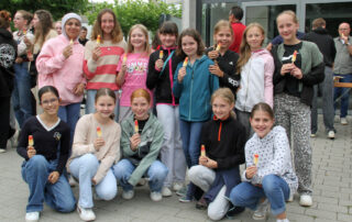 Schülerinnen genießen das Eis, das die Schulleitung zum Abschied in die Sommerferien spendierte.