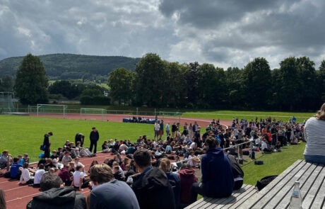 Schülerinnen und Schüler sitzen auf der Tribüne des Spaichinger Stadions