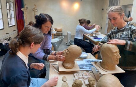 Schüler und Schülerinnen des Leistungskurses Kunst modellieren eine Kopf aus Ton.