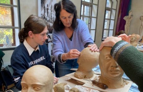 Ein Schüler des Leistungskurses Kunst modellieren eine Kopf aus Ton.