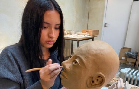 Schüler und Schülerinnen des Leistungskurses Kunst modellieren eine Kopf aus Ton.