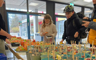 Eine Schülerin und ein Schüler suchen sich etwas Leckeres vom Büffet aus.