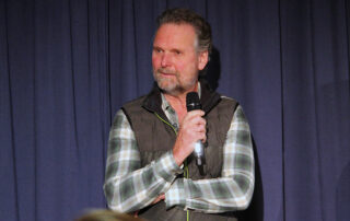 Herbert Schnee auf der Bühne der Aula des Gymnasiums Spaichingen