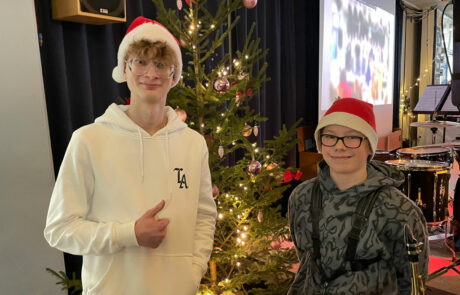 Zwei Schüler vor dem Weihnachtsbaum