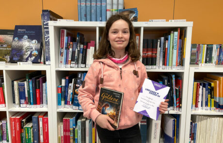 Maira Spiegel mit ihrer Siegerurkunde und dem Buch "Die goldenen Schreibmaschine"