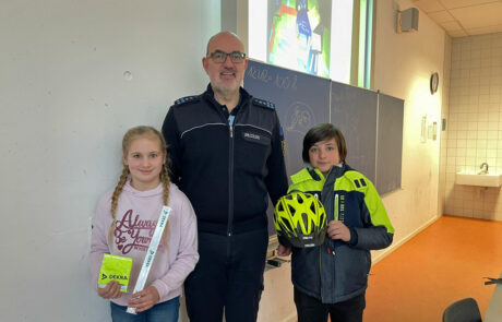 Polizist Holger Jauch mit einem Schüler und einer Schülerin der fünften Klasse